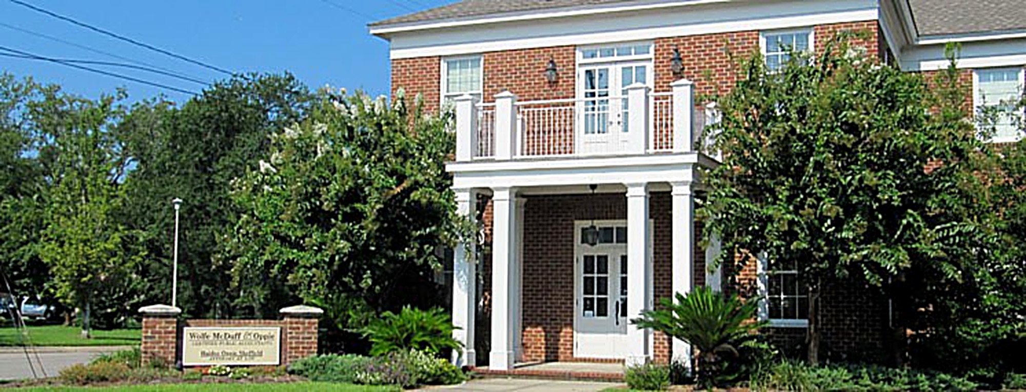 The Wolfe, McDuff & Oppie office, a two-story brick building with white columns on Pascagoula Street